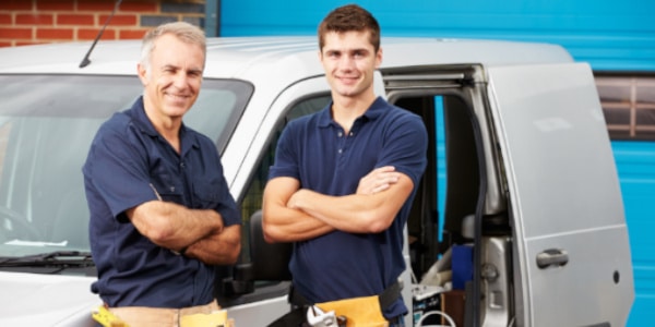 Workers In Family Business Standing Next To Van