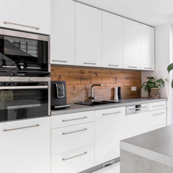 Balanced kitchen with white cabinets grey worktop and natural accents